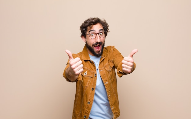 Young cool and crazy man against flat wall