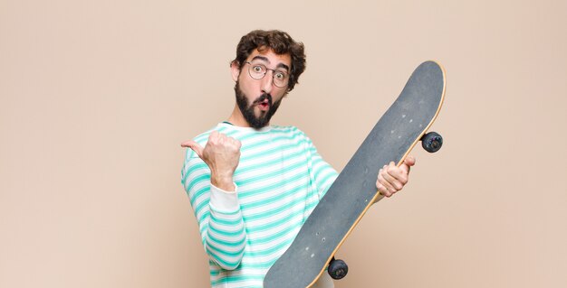 Young cool man bearded with a skate board