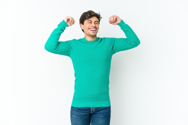 Young cool man celebrating a special day, jumps and raise arms with energy.