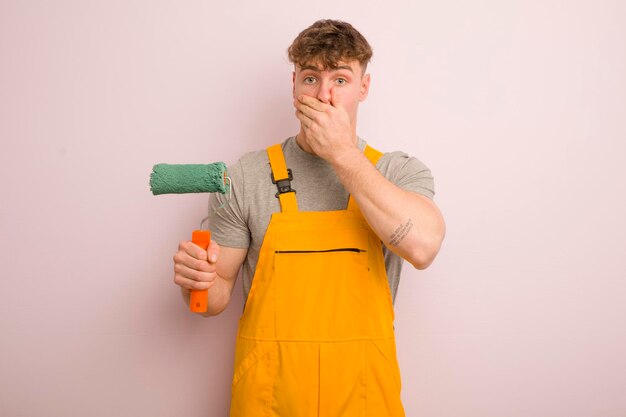 Young cool man covering mouth with hands with a shocked home improvement concept