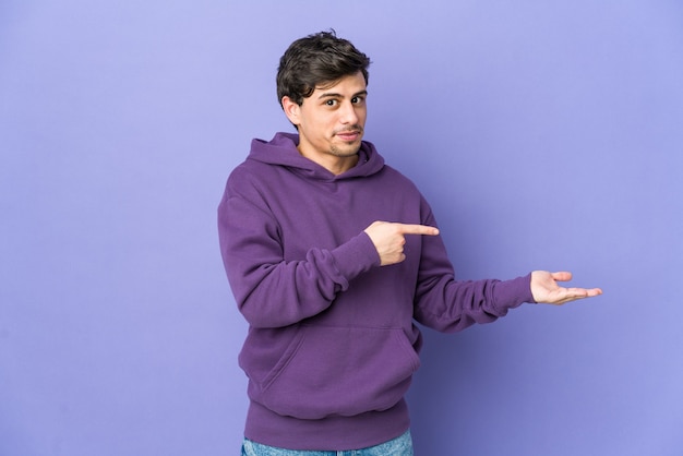 Young cool man excited pointing to something