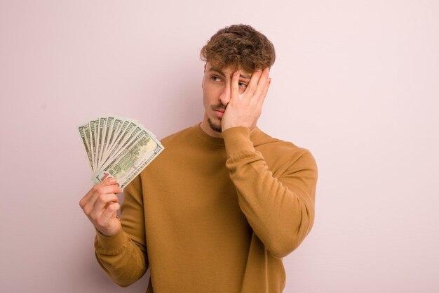 Photo young cool man feeling bored frustrated and sleepy after a tiresome dollar banknotes concept