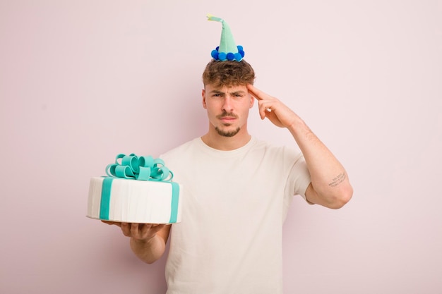 Young cool man feeling confused and puzzled showing you are insane birthday concept