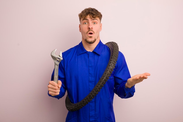 Young cool man feeling extremely shocked and surprised bike repairman concept