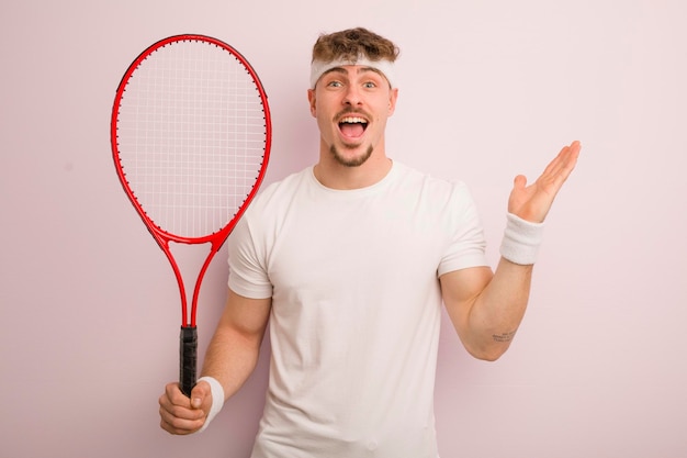 Young cool man feeling happy and astonished at something unbelievable tennis concept