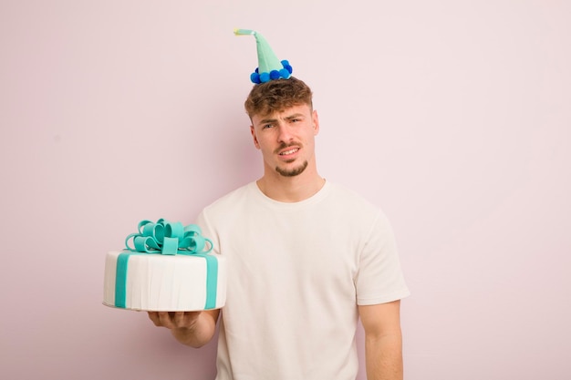 Young cool man feeling puzzled and confused birthday concept