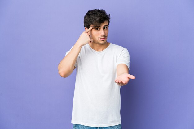 Young cool man holding and showing a product on hand