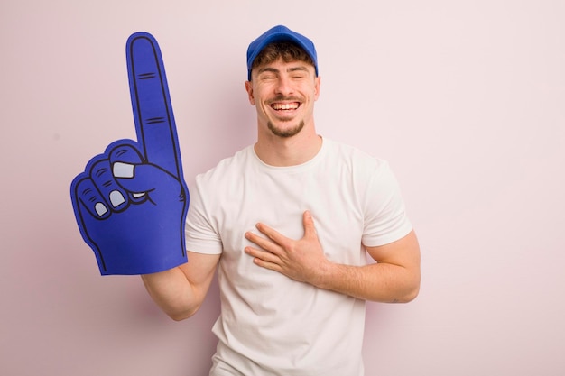 Young cool man laughing out loud at some hilarious joke number one fan concept