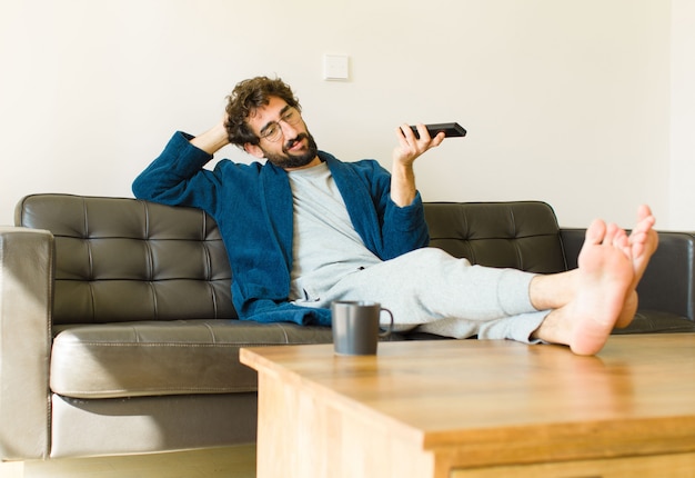 テレビを見てリビングルームのソファーに座っているクールな若者