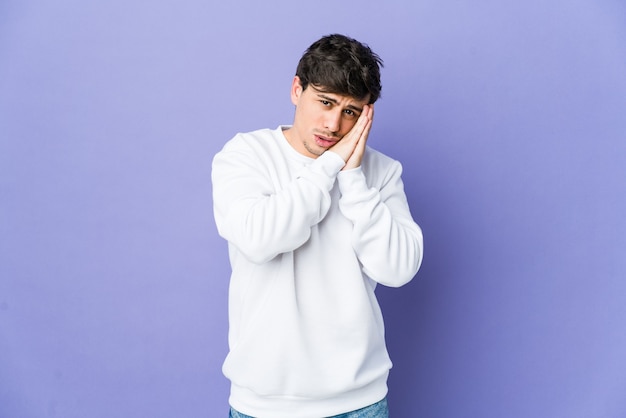 Young cool man yawning showing a tired gesture covering mouth with hand.