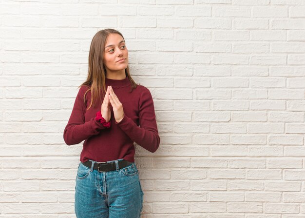 Photo young cool woman over a bricks wall devising a plan