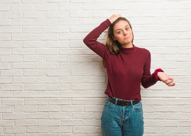 Young cool woman over a bricks wall worried and overwhelmed