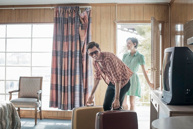 A young couple arriving in a motel room