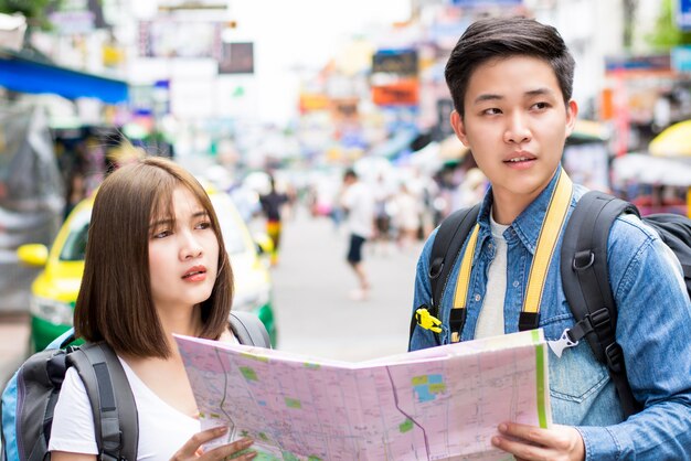 Young couple Asian tourist backpacker getting lost and looking for direction