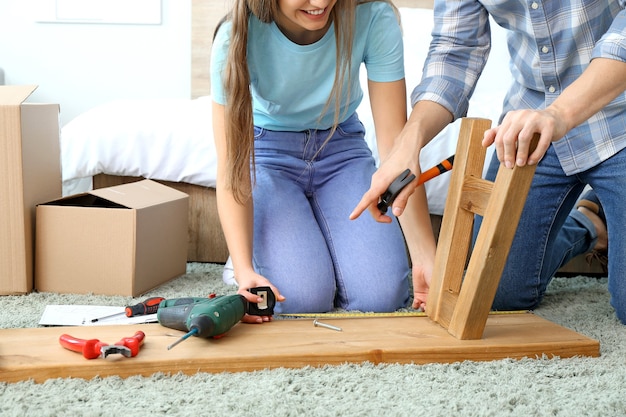 Young couple assembling furniture at home