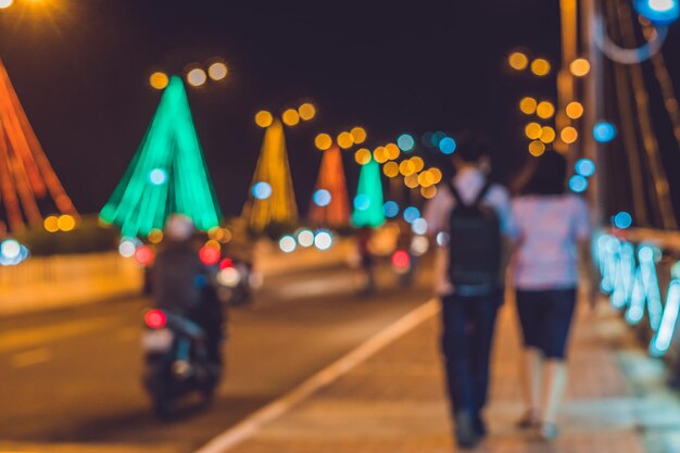 Giovane coppia sullo sfondo traffico intenso su un ponte di notte. supporti per ponti luminosi. messa a fuoco sfocata.