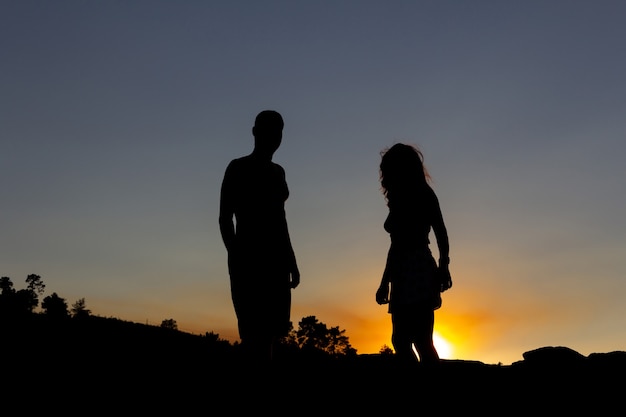 Giovane coppia retroilluminata al tramonto. copia spazio.