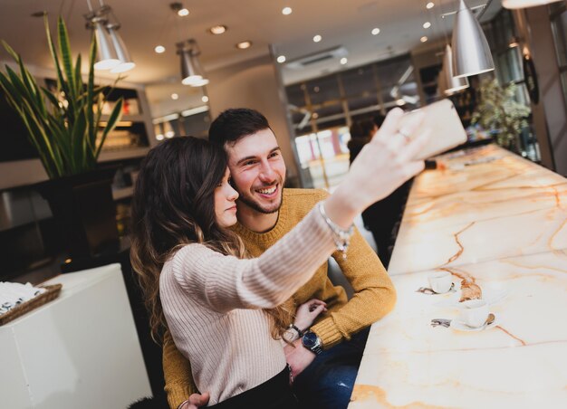 술집에서 젊은 부부는 selfie를 복용.