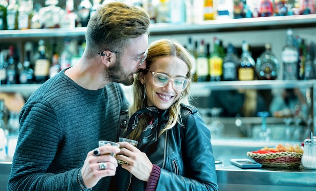 Giovani coppie all'inizio della storia d'amore nel cocktail bar - filtro verdastro