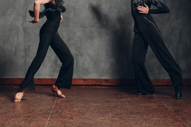 Young couple in black dress dancing in ballroom dance chachacha