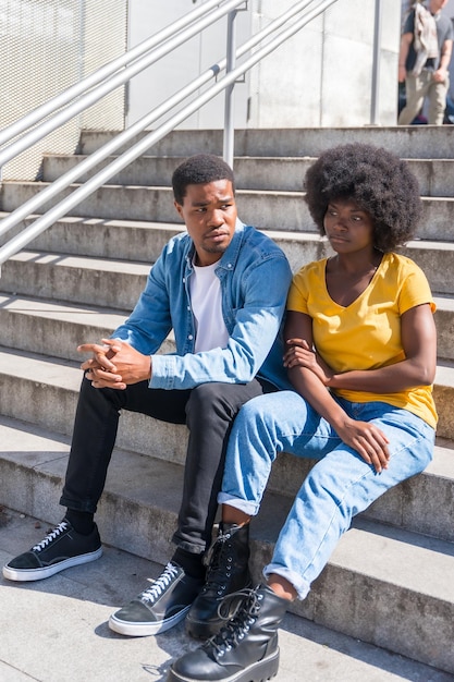 Young couple of black ethnicity sitting in the city in the sitting on the stairs