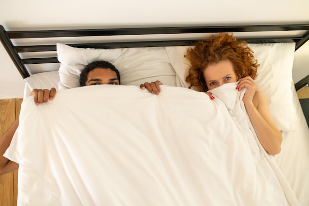 Photo young couple under the blanket in bed in the morning