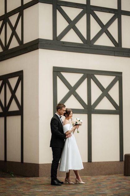 Photo young couple bride and groom in a white short dress