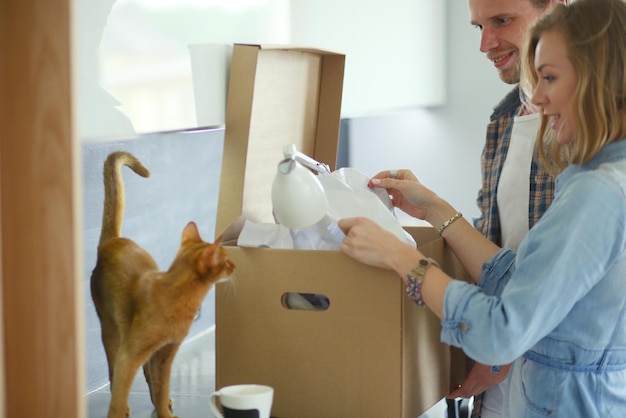 Young couple carrying big cardboard box at new homeMoving house Young couple