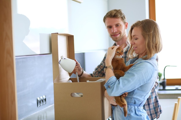 Young couple carrying big cardboard box at new homeMoving house Young couple