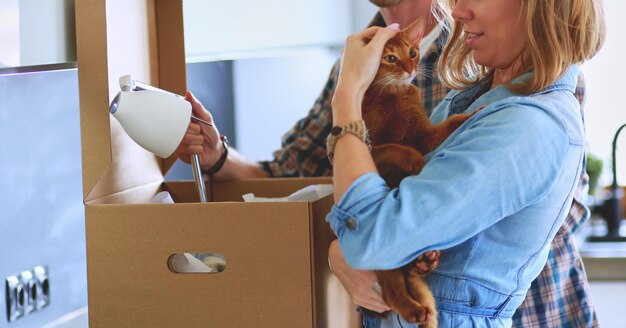 Young couple carrying big cardboard box at new homeMoving house Young couple