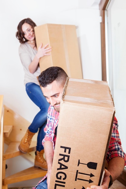 Фото Молодая пара носит коробки в новом доме