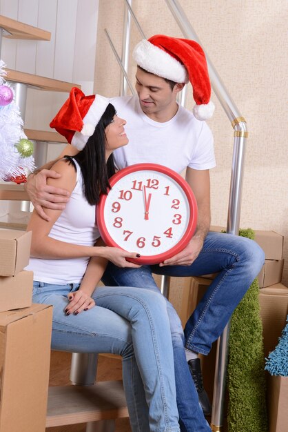 Young couple celebrating New Years in new home on stairs background