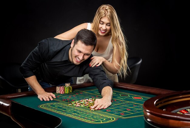 Young couple celebrating win at roulette table in casino