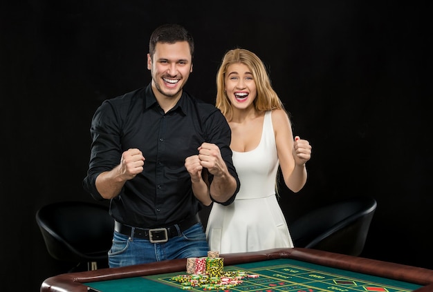 Young couple celebrating win at roulette table in casino