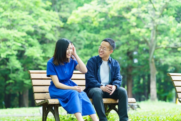 공원 벤치에서 채팅 하는 젊은 부부