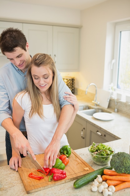 Young couple chopping peppers