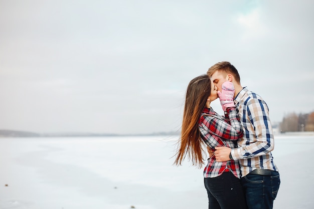 Молодая пара в яркой рубашке ходить в снежном парке