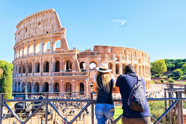 Coppia giovane al colosseo nel centro storico di roma, italia. è l'anfiteatro di roma.