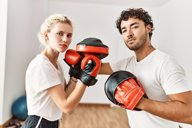 Молодая пара сосредоточилась на тренировках по боксу в спортивном центре