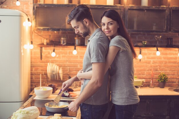 Photo young couple cooking in kitchen