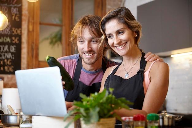 Photo young couple cooking and sharing online cooking tutorial