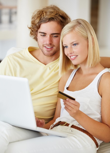 Photo young couple credit card and laptop for home online shopping loan and digital money on a sofa happy woman and man on computer for internet banking easy website payment or e commerce registration