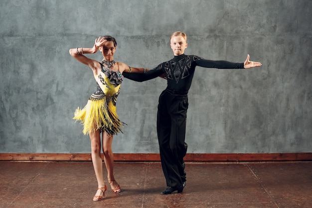 Young couple dancers dancing ballroom dance cha-cha-cha.