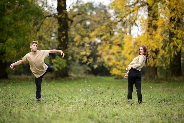 Young couple dancing on grassy field at park