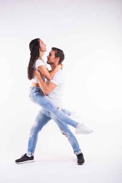 Young couple dancing social latin dance bachata, merengue, salsa. Two elegance pose on white background.