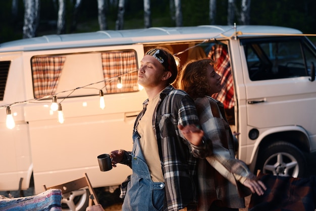 Photo young couple dancing together during camping in the forest