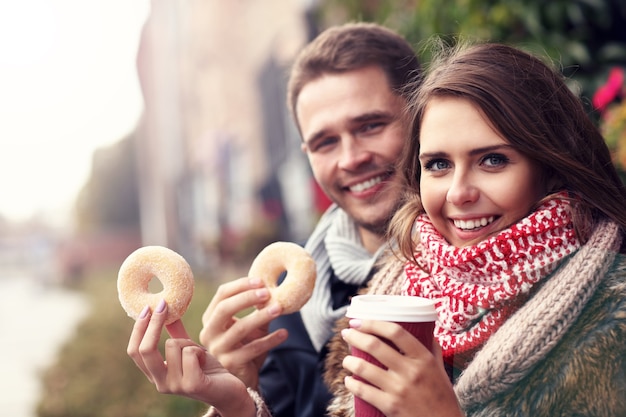 young couple on date in the city with coffee and donuts