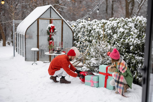 Young couple decorates christmas tree at backyard