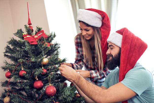 Young couple decorating a Christmas tree