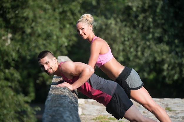 Young Couple Doing Pushups Before Running Outdoors - Fitness Healthy Lifestyle Concept